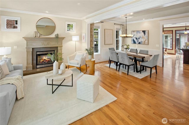 2621 NE Park Dr, Issaquah, WA 98029 - living area featuring wood finished floors, ornamental molding, a fireplace, and a chandelier