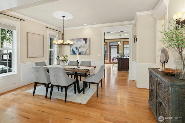 2621 NE Park Dr, Issaquah, WA 98029 - dining room with crown molding, light wood-type flooring, a wainscoted wall, a chandelier, and a decorative wall