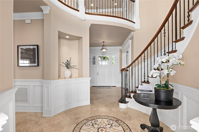8071 W Mercer Way, Mercer Island, WA 98040 - foyer entrance with a high ceiling, a decorative wall, stairway, wainscoting, and light marble finish flooring