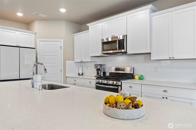 32803 Stuart Ave SE, Black Diamond, WA 98010 - kitchen with stainless steel appliances, white cabinets, backsplash, and recessed lighting