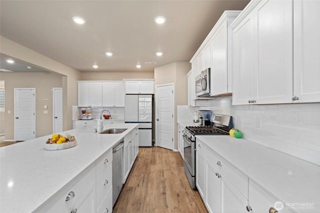 32803 Stuart Ave SE, Black Diamond, WA 98010 - kitchen featuring stainless steel appliances, white cabinetry, recessed lighting, tasteful backsplash, and light wood-style flooring