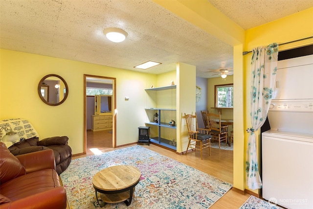 215 Amber Ln, Sequim, WA 98382 - living room featuring estacked washer and dryer, a textured ceiling, wood finished floors, and ceiling fan