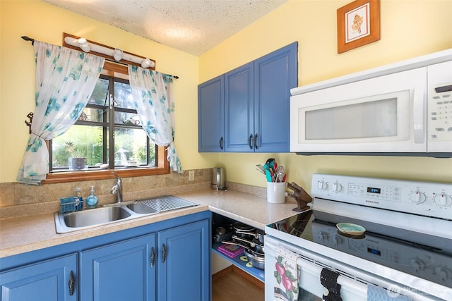 215 Amber Ln, Sequim, WA 98382 - kitchen with white appliances, blue cabinetry, light countertops, and a textured ceiling