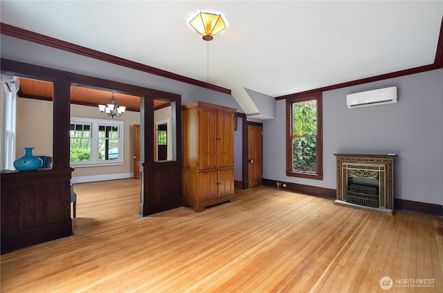 1114 5th Ave SW, Olympia, WA 98502 - unfurnished living room featuring a wall mounted AC, a chandelier, light wood-style flooring, ornamental molding, and a fireplace