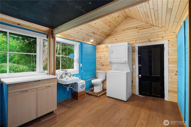 1114 5th Ave SW, Olympia, WA 98502 - laundry area with stacked washer / dryer, wooden ceiling, wooden walls, and wood-type flooring