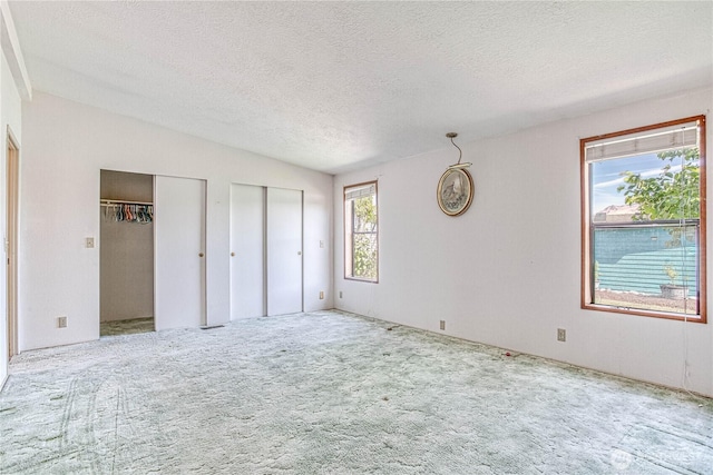 1700 Twin Peaks Dr Unit 71, Wenatchee, WA 98801 - unfurnished bedroom with two closets, a textured ceiling, and carpet floors
