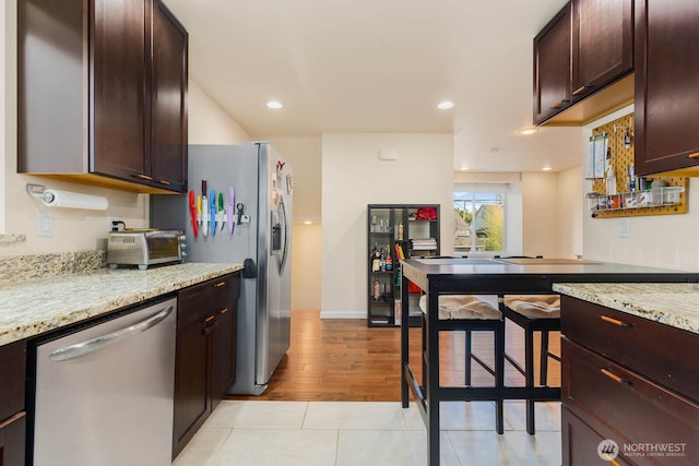 5798 Roosevelt Way NE, Seattle, WA 98105 - kitchen featuring stainless steel dishwasher, dark brown cabinetry, light stone countertops, light tile patterned flooring, and recessed lighting