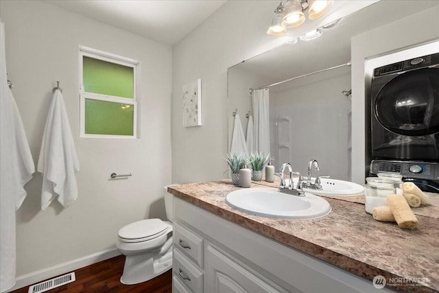 17019 426th Ave SE, North Bend, WA 98045 - full bath featuring stacked washer / drying machine, vanity, curtained shower, and wood finished floors