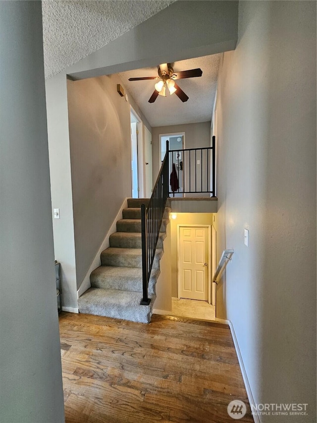 10924 SE 183rd Ct, Renton, WA 98055 - stairway featuring ceiling fan, wood finished floors, and a textured ceiling