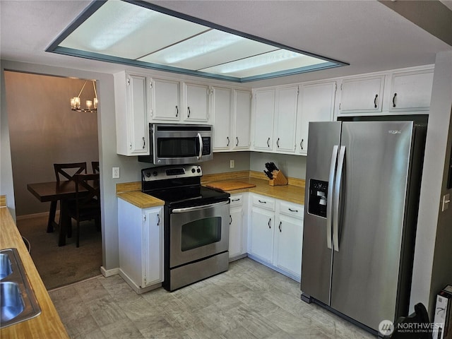 10924 SE 183rd Ct, Renton, WA 98055 - kitchen featuring appliances with stainless steel finishes, a chandelier, light floors, and white cabinetry