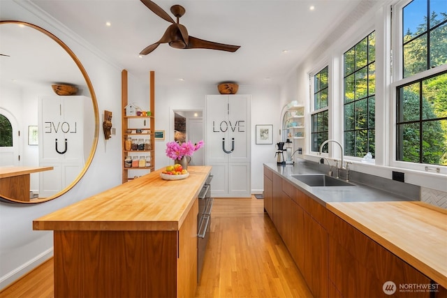 kitchen featuring butcher block countertops, light wood-style floors, healthy amount of natural light, a ceiling fan, and recessed lighting