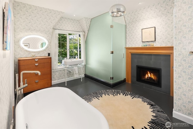 bedroom featuring wallpapered walls and a fireplace with flush hearth