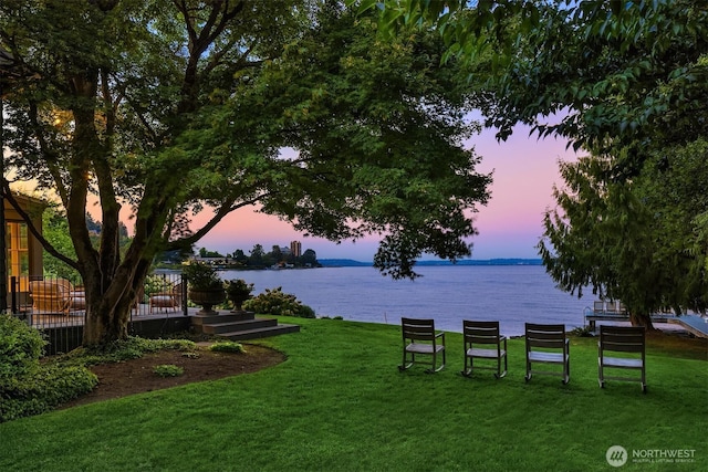 view of community featuring a water view and a yard
