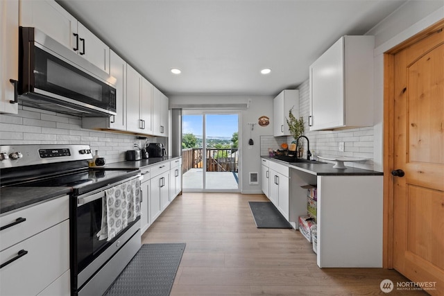 755 S Chelan Ave, Wenatchee, WA 98801 - kitchen with appliances with stainless steel finishes, dark countertops, decorative backsplash, white cabinets, and recessed lighting