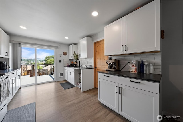 755 S Chelan Ave, Wenatchee, WA 98801 - kitchen featuring backsplash, white cabinets, light wood-style flooring, dark countertops, and recessed lighting