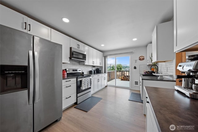 755 S Chelan Ave, Wenatchee, WA 98801 - kitchen featuring appliances with stainless steel finishes, dark countertops, decorative backsplash, light wood-type flooring, and recessed lighting