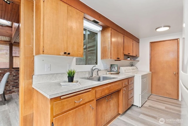 15633 47th Ave S, Tukwila, WA 98188 - kitchen with separate washer and dryer, light wood-style floors, light countertops, and brown cabinets