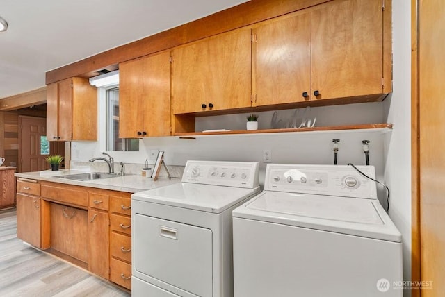 15633 47th Ave S, Tukwila, WA 98188 - washroom featuring cabinet space, washing machine and clothes dryer, and light wood-type flooring