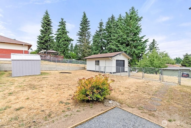 15633 47th Ave S, Tukwila, WA 98188 - fenced backyard featuring a gate, an outdoor structure, and a detached garage