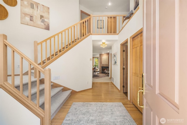 11926 SE 198th Ct, Kent, WA 98031 - entrance foyer featuring light wood-type flooring, stairway, a large fireplace, and a high ceiling