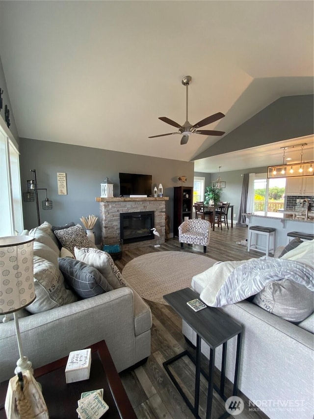 1111 Riverside Ct, Ocean Shores, WA 98569 - living room featuring lofted ceiling, a ceiling fan, wood finished floors, and a fireplace