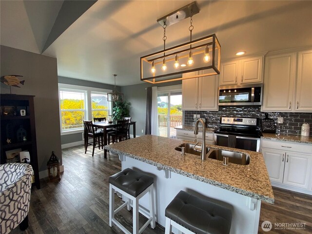 1111 Riverside Ct, Ocean Shores, WA 98569 - kitchen with appliances with stainless steel finishes, tasteful backsplash, dark wood-type flooring, and white cabinets