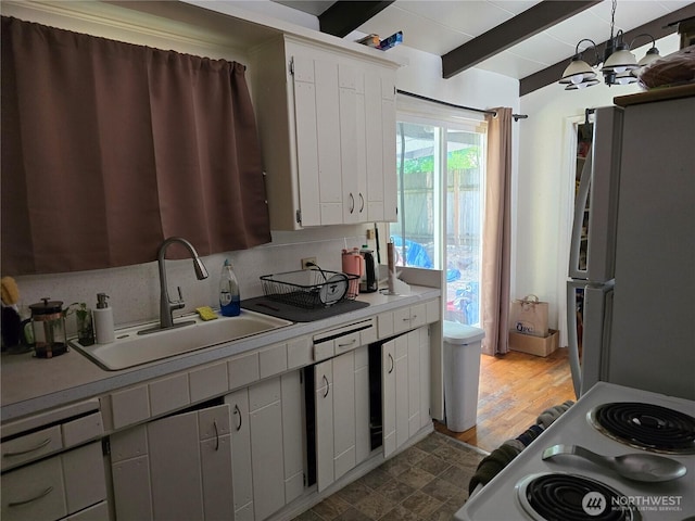 1208 NE 110th St, Seattle, WA 98125 - kitchen with freestanding refrigerator, range, light countertops, beam ceiling, and white cabinetry