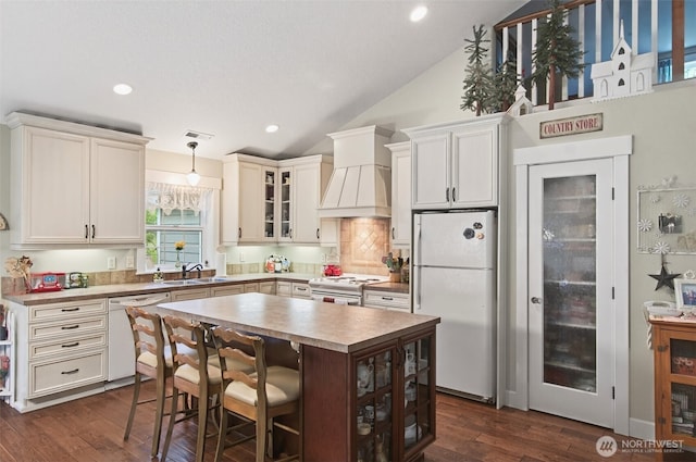 721 Abernathy Creek Rd, Longview, WA 98632 - kitchen with white appliances, lofted ceiling, glass insert cabinets, custom range hood, and decorative backsplash