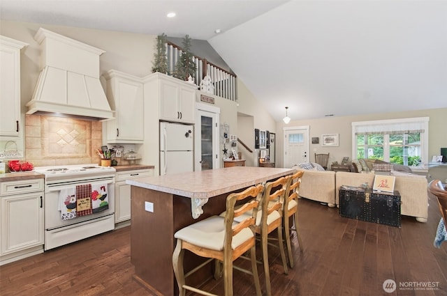 721 Abernathy Creek Rd, Longview, WA 98632 - kitchen with white appliances, custom range hood, a center island, dark wood finished floors, and high vaulted ceiling