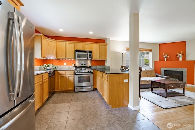 2740 Undine Pl, Bellingham, WA 98226 - kitchen featuring appliances with stainless steel finishes, open floor plan, a tiled fireplace, recessed lighting, and a peninsula
