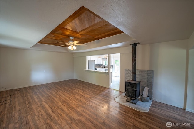 1117 W Stockwell St, Aberdeen, WA 98520 - unfurnished living room featuring a ceiling fan, wood finished floors, and a wood stove