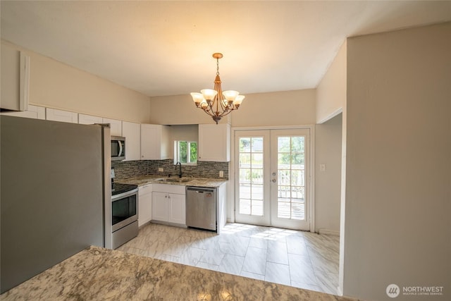 1117 W Stockwell St, Aberdeen, WA 98520 - kitchen featuring stainless steel appliances, a chandelier, white cabinetry, and backsplash