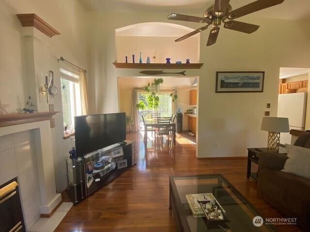 5846 SW 44th St, Port Orchard, WA 98367 - living area with a fireplace, wood finished floors, ceiling fan, and a high ceiling