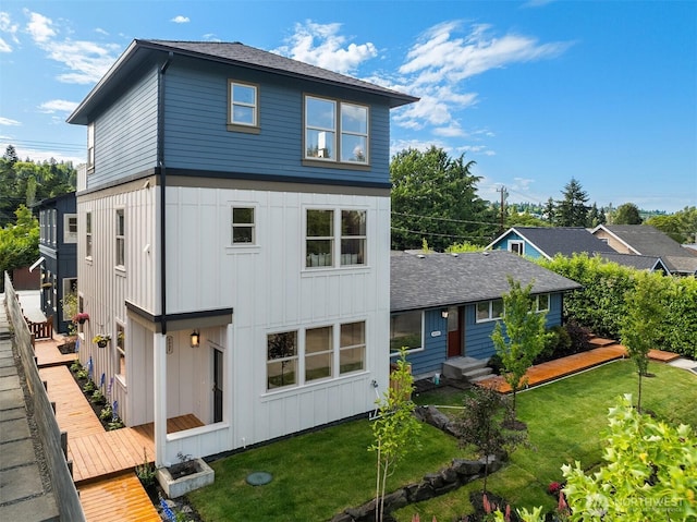 5037 25th Ave SW, Seattle, WA 98106 - rear view of property with board and batten siding, a yard, and a shingled roof