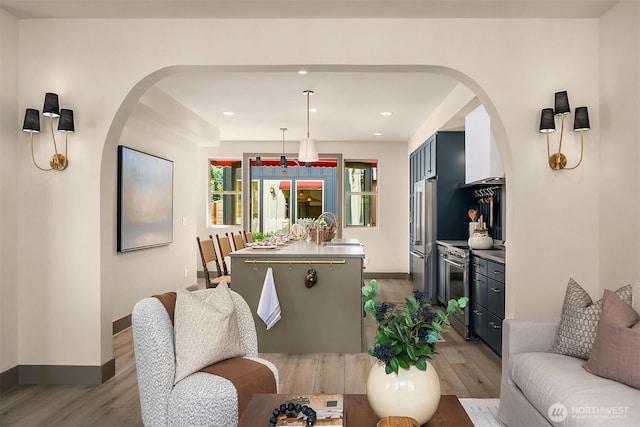 5037 25th Ave SW, Seattle, WA 98106 - living room featuring light wood-style floors, arched walkways, and recessed lighting