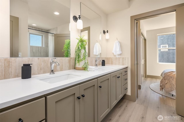5037 25th Ave SW, Seattle, WA 98106 - bathroom with double vanity, wood finished floors, tasteful backsplash, ensuite bathroom, and recessed lighting