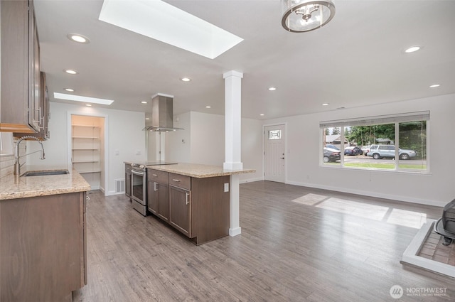 16812 125th Ave SE, Renton, WA 98058 - kitchen with stainless steel range with electric cooktop, island range hood, decorative columns, a skylight, and recessed lighting