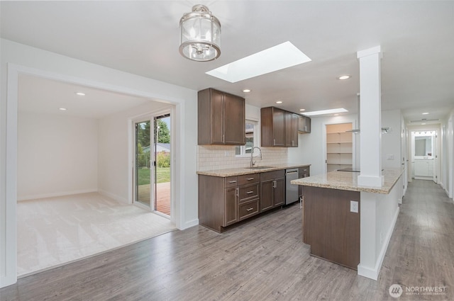 16812 125th Ave SE, Renton, WA 98058 - kitchen with stainless steel dishwasher, light wood-type flooring, a skylight, light stone counters, and recessed lighting