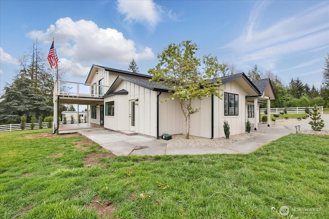 150 Cliff Robinson Ln, Sequim, WA 98382 - rear view of house featuring board and batten siding, a balcony, and a patio