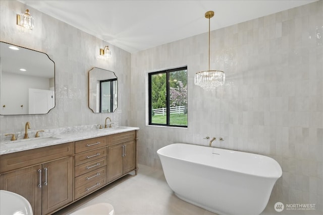 150 Cliff Robinson Ln, Sequim, WA 98382 - bathroom with tile walls, a freestanding tub, double vanity, a chandelier, and tile patterned floors