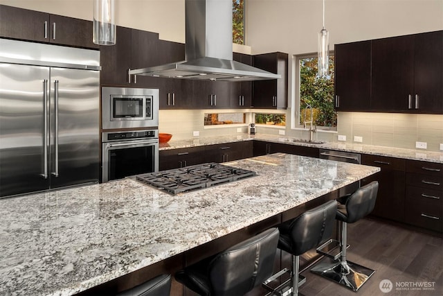 3003 Mountain View Ave N, Renton, WA 98056 - kitchen with built in appliances, wall chimney range hood, a kitchen bar, and light stone countertops