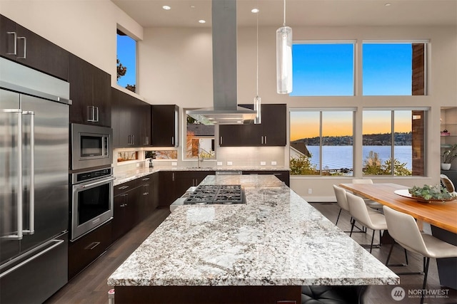 3003 Mountain View Ave N, Renton, WA 98056 - kitchen with built in appliances, island exhaust hood, a high ceiling, a kitchen island, and light stone countertops