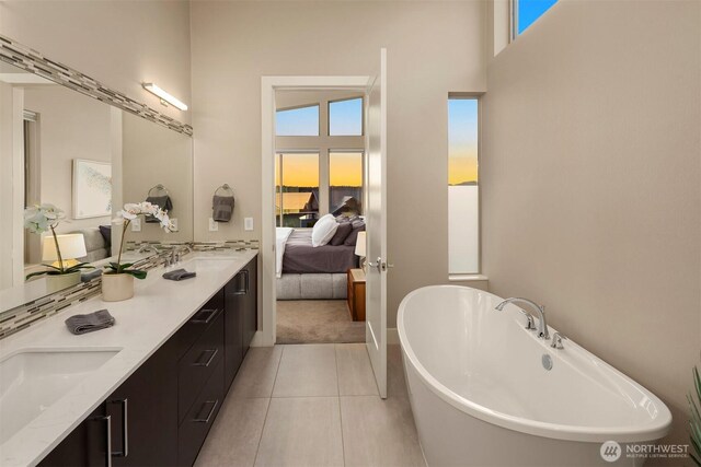 3003 Mountain View Ave N, Renton, WA 98056 - ensuite bathroom featuring double vanity, a freestanding tub, tile patterned flooring, and a towering ceiling