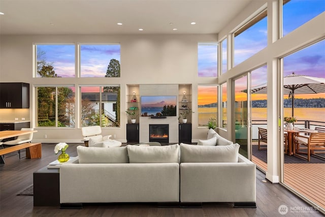 3003 Mountain View Ave N, Renton, WA 98056 - living room with a towering ceiling, a glass covered fireplace, healthy amount of natural light, recessed lighting, and dark wood-type flooring