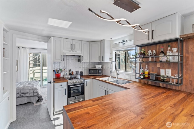 2401 N Northlake Way Unit F6, Seattle, WA 98103 - kitchen featuring wood counters, stainless steel appliances, under cabinet range hood, open shelves, and tasteful backsplash