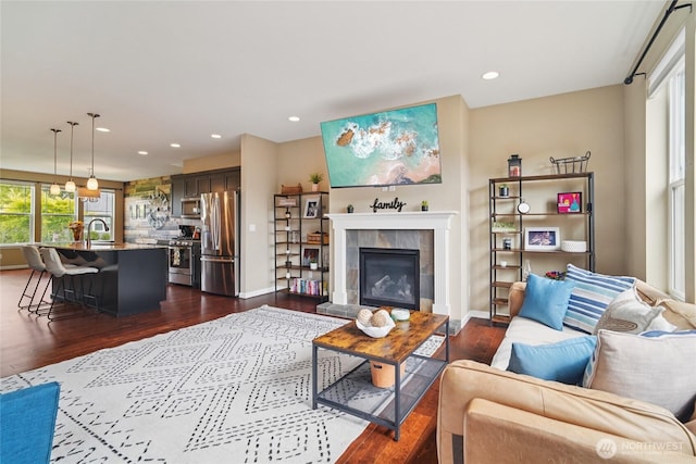 13712 Big Sky Dr E, Bonney Lake, WA 98391 - living area featuring dark wood-type flooring, recessed lighting, and a tiled fireplace