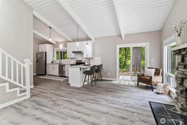1535 Ten Mile Rd, Everson, WA 98247 - kitchen with appliances with stainless steel finishes, a kitchen breakfast bar, under cabinet range hood, white cabinetry, and open floor plan