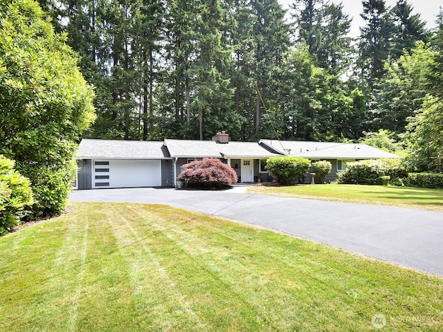 7819 25th Ave E, Tacoma, WA 98404 - ranch-style house featuring asphalt driveway, an attached garage, a chimney, and a front lawn