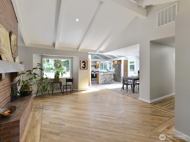 7819 25th Ave E, Tacoma, WA 98404 - foyer featuring beam ceiling, a brick fireplace, light wood-style floors, and high vaulted ceiling