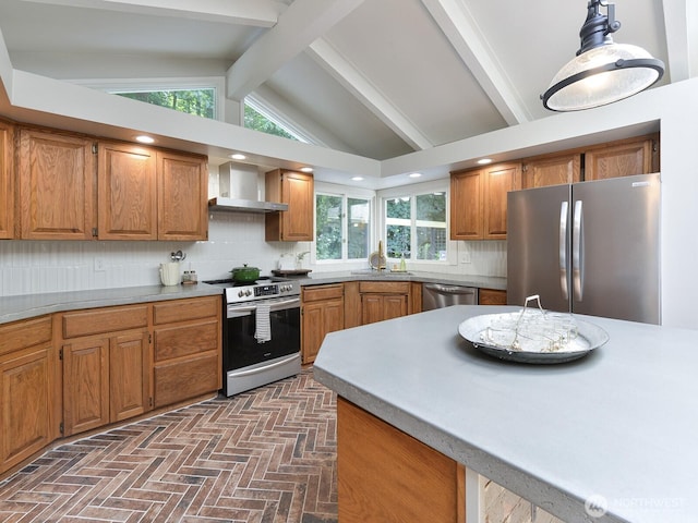 7819 25th Ave E, Tacoma, WA 98404 - kitchen with appliances with stainless steel finishes, wall chimney range hood, brown cabinetry, decorative backsplash, and brick floors